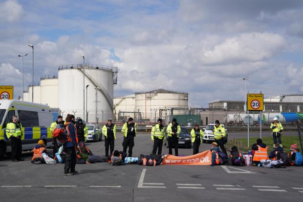 Oxford Mail: Police officers look at activists from Just Stop Oil taking part in a blockade at the Kingsbury Oil Terminal, Warwickshire. Picture date: Sunday April 3, 2022. By Jacob King. 